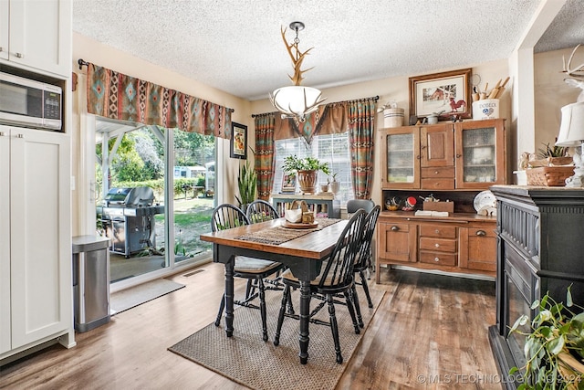 dining space featuring a textured ceiling and light hardwood / wood-style flooring