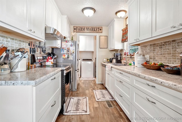 kitchen with backsplash, white cabinets, light hardwood / wood-style flooring, stainless steel appliances, and washer / clothes dryer