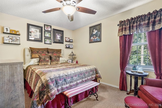 carpeted bedroom featuring ceiling fan and a textured ceiling