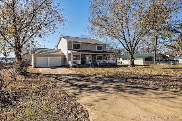 view of front of property featuring a garage, covered porch, and an outdoor structure