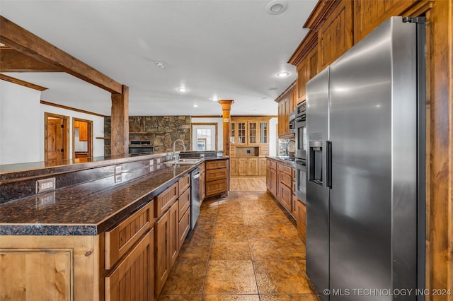 kitchen with sink, ornamental molding, ornate columns, appliances with stainless steel finishes, and a large island