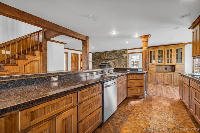 kitchen with ornate columns, sink, dark stone countertops, crown molding, and appliances with stainless steel finishes