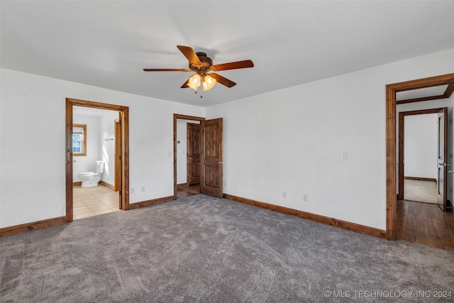 unfurnished bedroom featuring connected bathroom, light colored carpet, and ceiling fan