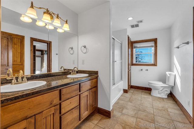 full bathroom with vanity, bath / shower combo with glass door, and toilet