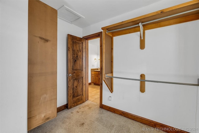 spacious closet featuring light colored carpet