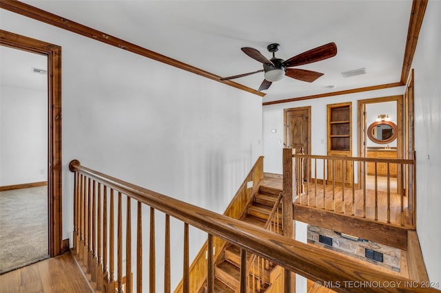 stairs featuring ceiling fan, hardwood / wood-style floors, and crown molding