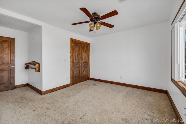 carpeted spare room with ceiling fan