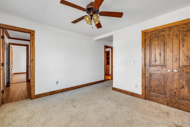 unfurnished bedroom with light carpet, a closet, and ceiling fan