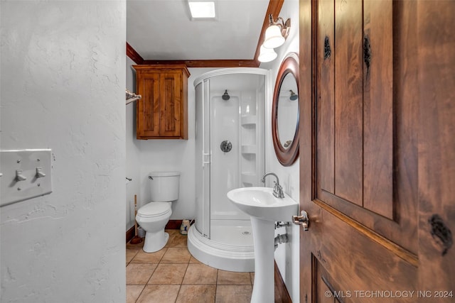 bathroom with tile patterned floors, a shower with shower door, and toilet