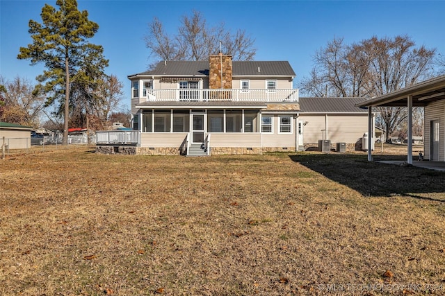 rear view of property featuring a yard, a sunroom, a balcony, and central AC unit