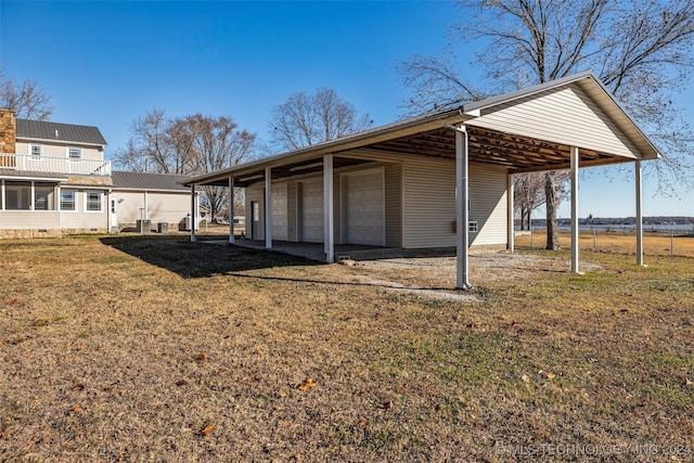 rear view of house with a yard, an outbuilding, a carport, and a garage