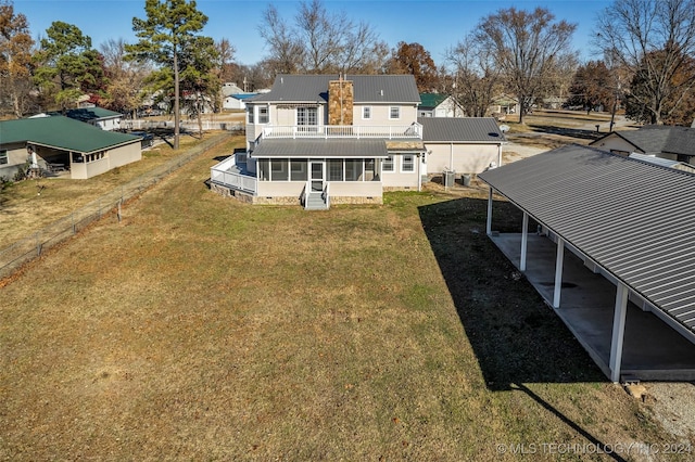 rear view of property featuring a sunroom and a lawn