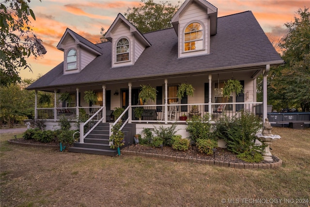 view of front of house with a lawn and a porch