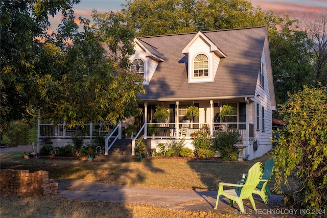 view of front of property with a porch and a yard