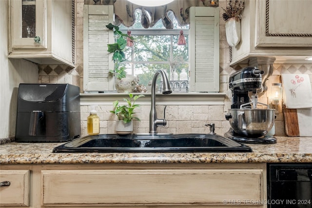 kitchen featuring sink, light brown cabinetry, and tasteful backsplash