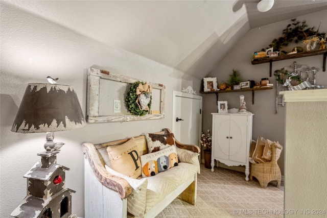 sitting room with light colored carpet and vaulted ceiling