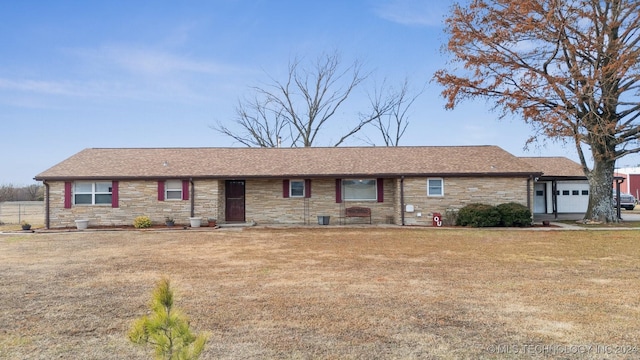 ranch-style home featuring stone siding, a front lawn, and an attached garage