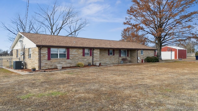 ranch-style house featuring stone siding, an outbuilding, a gate, cooling unit, and a front yard