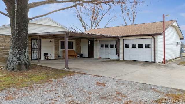 ranch-style house featuring driveway, stone siding, roof with shingles, and an attached garage