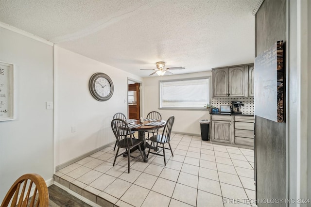 dining room featuring ceiling fan, baseboards, a textured ceiling, and light tile patterned flooring