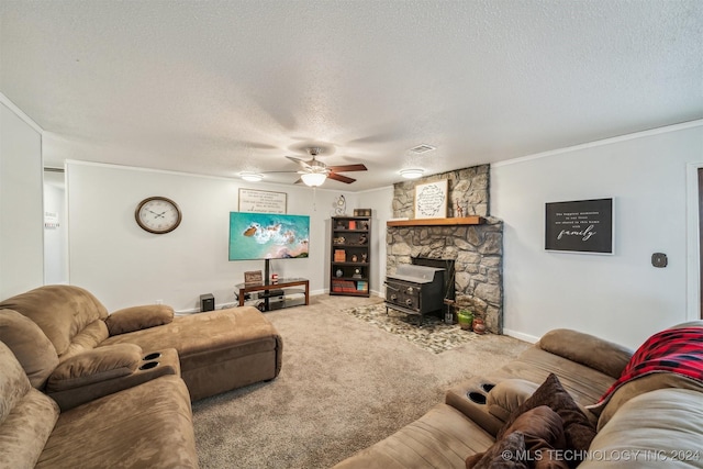 living room featuring a textured ceiling, ceiling fan, carpet floors, baseboards, and crown molding