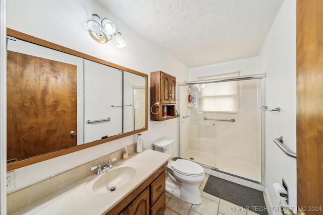 full bath with a textured ceiling, toilet, vanity, a shower stall, and tile patterned floors