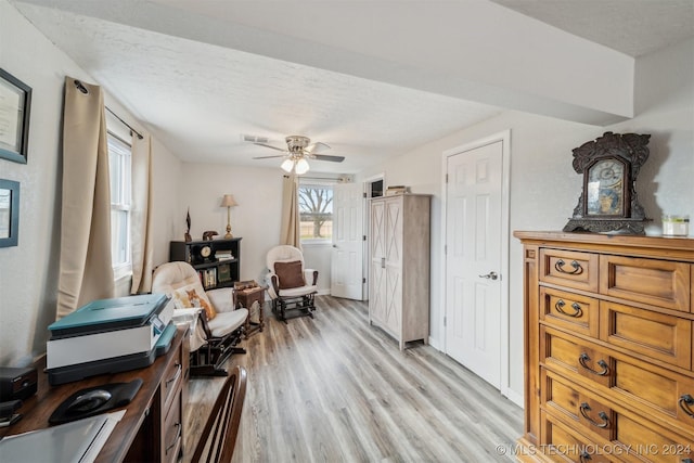 sitting room with a ceiling fan, visible vents, light wood-style flooring, and a textured ceiling