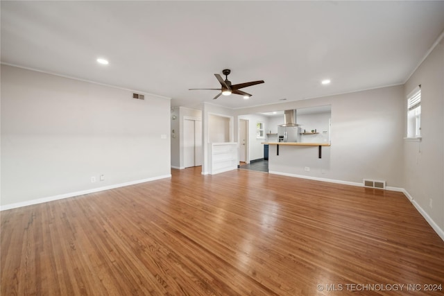 unfurnished living room with ceiling fan, ornamental molding, and hardwood / wood-style flooring