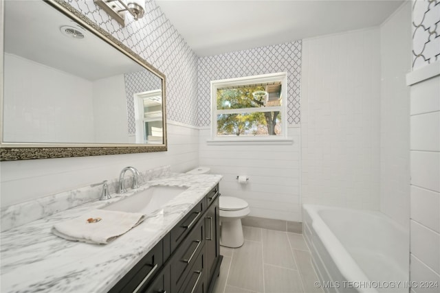 bathroom with toilet, vanity, and tile patterned floors