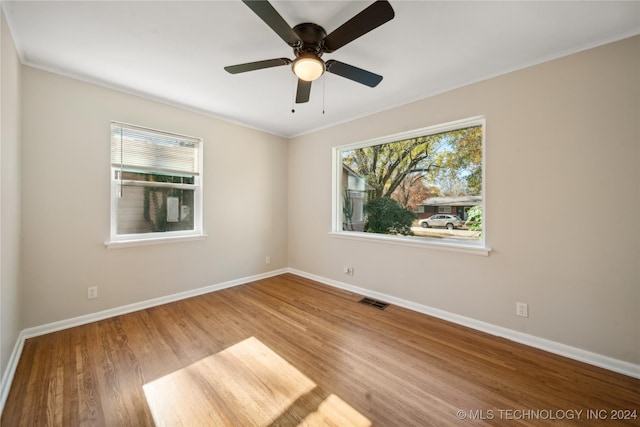 empty room with light wood-type flooring, ceiling fan, and ornamental molding