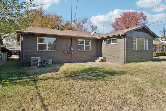 back of house featuring a lawn and central AC