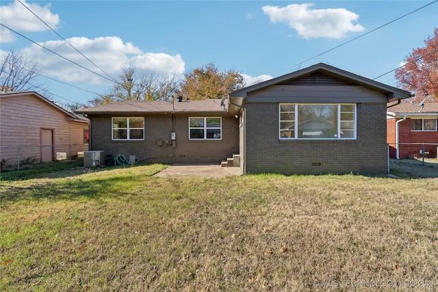 rear view of property with a yard, a patio, and central AC unit