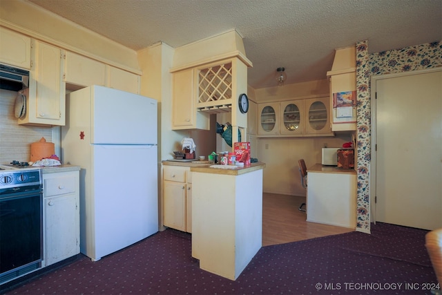 kitchen with kitchen peninsula, exhaust hood, range, white fridge, and dark hardwood / wood-style floors