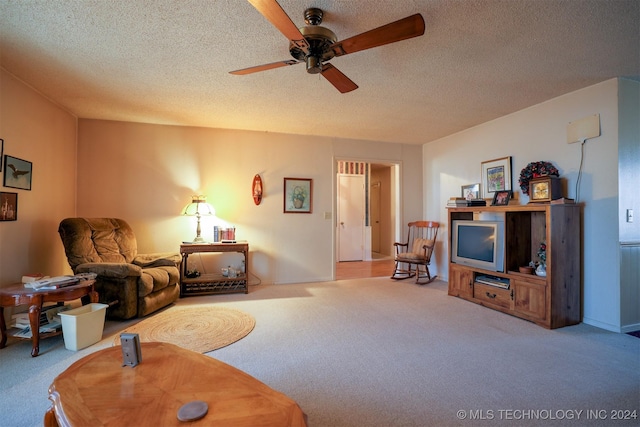 carpeted living room with ceiling fan and a textured ceiling