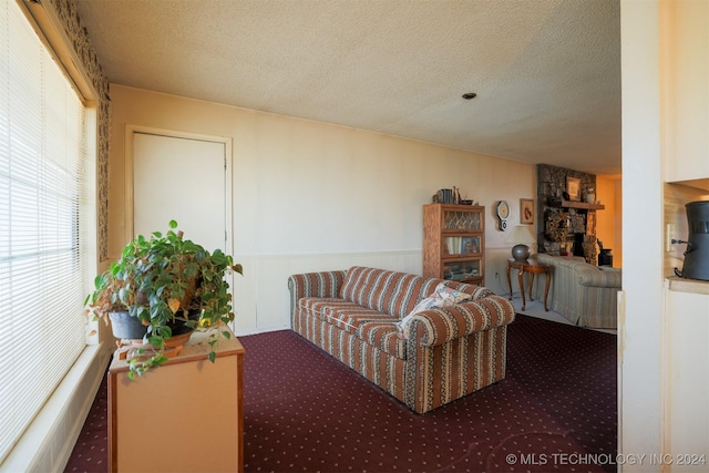 living room featuring a fireplace, a textured ceiling, and carpet floors