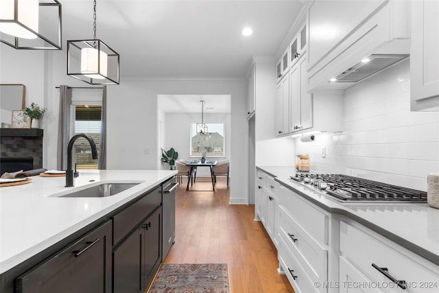 kitchen featuring sink, white cabinets, and pendant lighting