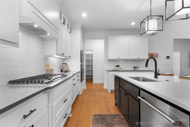 kitchen with decorative light fixtures, white cabinetry, sink, and stainless steel appliances