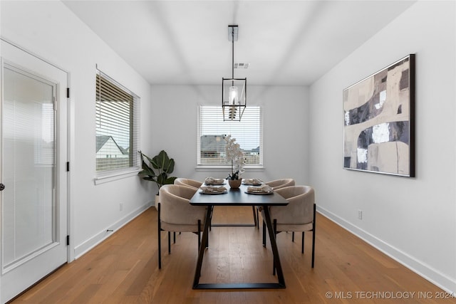 dining room with hardwood / wood-style flooring and a notable chandelier