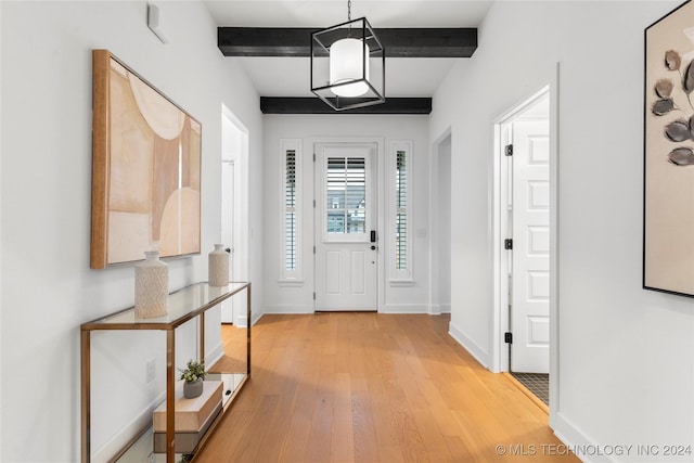 entryway featuring beamed ceiling and light wood-type flooring