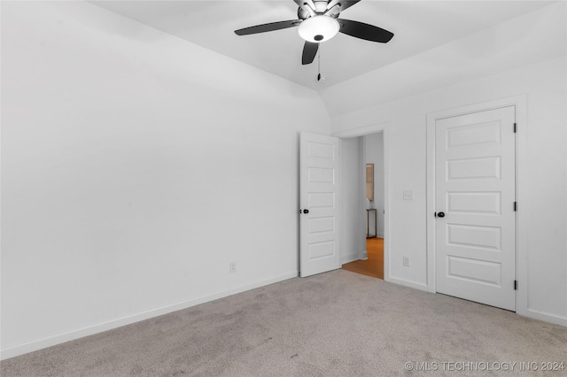 carpeted spare room featuring ceiling fan and lofted ceiling