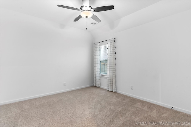 carpeted spare room with ceiling fan and vaulted ceiling