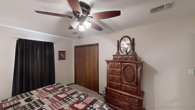 bedroom with light colored carpet, a textured ceiling, and ceiling fan