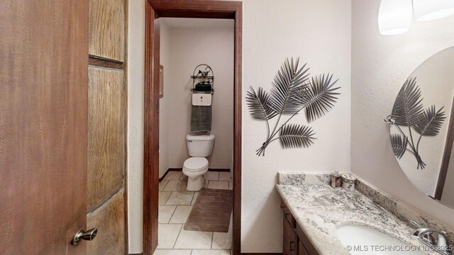 bathroom featuring vanity, toilet, and tile patterned floors