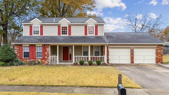 view of front property with a porch, a garage, and a front yard