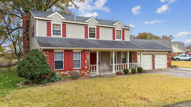 front facade featuring a front lawn, covered porch, and a garage