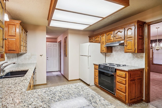 kitchen with pendant lighting, black range oven, white refrigerator, sink, and a chandelier