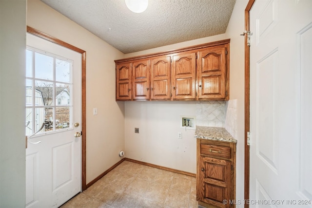 laundry room featuring cabinets, hookup for a washing machine, light tile patterned floors, a textured ceiling, and hookup for an electric dryer