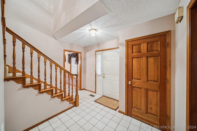 foyer with light tile patterned floors and a textured ceiling