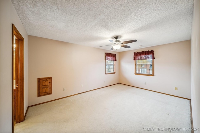 carpeted spare room with a textured ceiling and ceiling fan