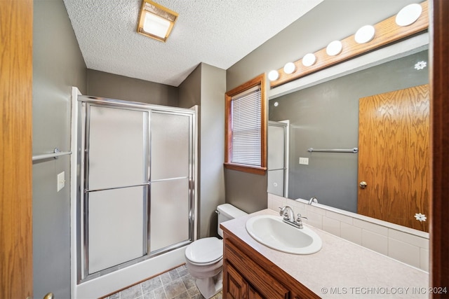 bathroom featuring vanity, toilet, a textured ceiling, and walk in shower